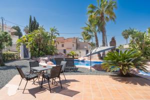 een terras met een tafel en stoelen naast een zwembad bij Villa Sardonyx CostaBlancaDreams in Calpe