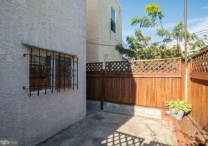 a building with a wooden fence and a gate at Historic Townhouse Oasis with En-suite Bathroom in Philadelphia