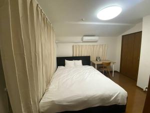 a bedroom with a large white bed and a desk at TOKYO池袋家族連れ4DKの子供連れ５星　 in Tokyo