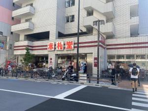 una persona con una sombrilla caminando delante de un edificio en TOKYO池袋家族連れ4DKの子供連れ５星　 en Tokio