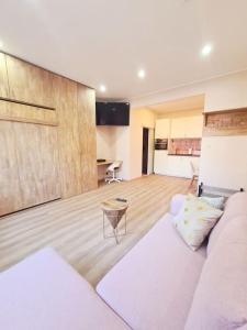 Il comprend un salon avec un canapé blanc et une cuisine. dans l'établissement Magnolia Pink Studio New and fully equipped, à Bruxelles