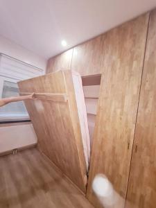 Cette chambre dispose d'un placard avec une porte en bois. dans l'établissement Magnolia Pink Studio New and fully equipped, à Bruxelles