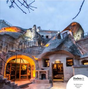 a house with a tree on top of it at Cappadocia Gamirasu Cave Hotel in Ayvalı