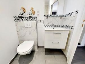 Un baño blanco con inodoro y lavabo. en Un havre de paix les pieds dans l'eau, en La Seyne-sur-Mer