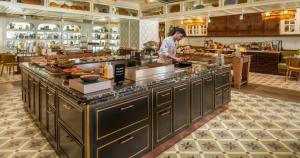 a chef preparing food in a large kitchen at Only YOU Hotel Sevilla in Seville