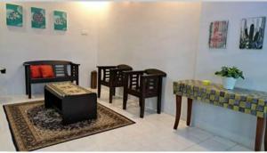 a living room with chairs and a table and a couch at Homestay Mukhriz in Kulim