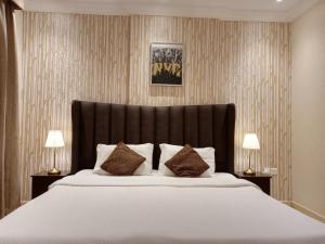 a bedroom with a large white bed with two lamps at فندق الفخامة in Jeddah
