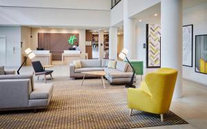 a lobby with couches and chairs and a table at Holiday Inn & Suites Oakville at Bronte, an IHG Hotel in Oakville