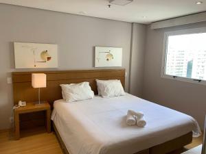 1 dormitorio con 1 cama blanca grande y ventana en GET A FLAT 81 - Confortável, en São Paulo