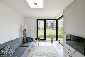 uma sala de estar com um sofá e uma grande janela em Golf Apartment 114 em Beroun