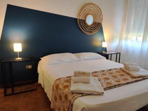 a bedroom with a large white bed with towels on it at Appartamento Anna in Desenzano del Garda