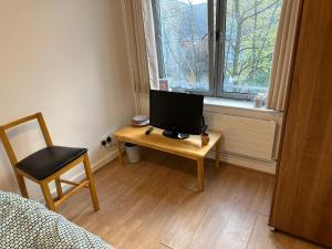 a bedroom with a desk with a television on it at Newbury in London