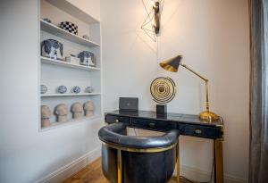 einen Schreibtisch mit einer Lampe und einem Stuhl in einem Zimmer in der Unterkunft Beautiful House in Knightsbridge in London