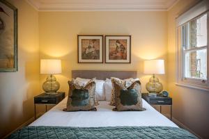 ein Schlafzimmer mit einem Bett mit zwei Lampen und einem Fenster in der Unterkunft Beautiful House in Knightsbridge in London