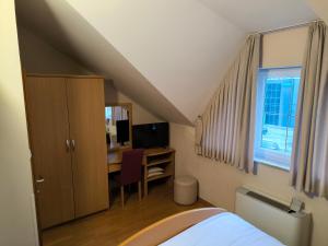 a bedroom with a bed and a desk with a computer at B&B Gurman in Sesvete