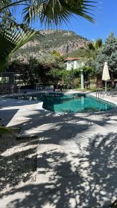 a swimming pool in a resort with a mountain in the background at Göcek Selya Hotel in Göcek