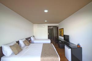 グラヴァターにあるHotel Fazenda Monte Casteloのベッドとテレビが備わるホテルルームです。