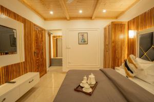 1 dormitorio con 1 cama, TV y mesa en PerfectStayz Paradise, en Mussoorie