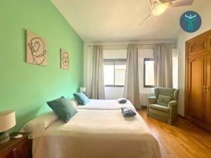 1 dormitorio con 1 cama grande y 1 silla en Dos Torres Ático Dúplex - Céntrico con Vistas a la Ciudad, en Zaragoza