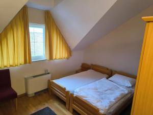 a bedroom with a bed and two windows at B&B Gurman in Sesvete