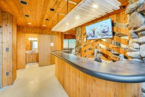 a bar in a cabin with a stone wall at Bloomfield Retreat with Indoor Pool and Tennis Court! in Bloomfield Hills