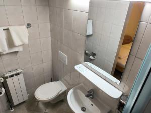 a bathroom with a toilet and a sink and a mirror at B&B Gurman in Sesvete