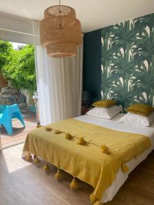 a bedroom with a large bed with a yellow blanket at Jasmin House in Cenon