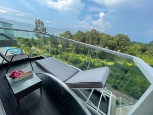邦萨雷Delmare Beachfront Bangsaray的建筑物上的阳台上有两把椅子和一张桌子