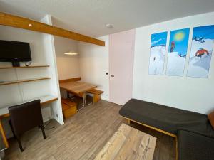 a living room with a bed and a desk at travelski home classic - Résidence Bellecôte in La Plagne +18 photos