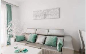 un soggiorno con divano e cuscini verdi e bianchi di KBM-1 a Cadice
