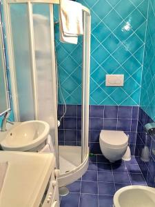 ein blau gefliestes Bad mit WC und Waschbecken in der Unterkunft Le Case della Costa - Apartment Positano in Maiori
