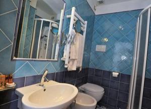 ein Badezimmer mit einem Waschbecken, einem WC und einem Spiegel in der Unterkunft Le Case della Costa - Apartment Positano in Maiori