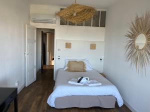 a bedroom with a bed with a basket on the wall at Hôtel Paradis in Bormes-les-Mimosas