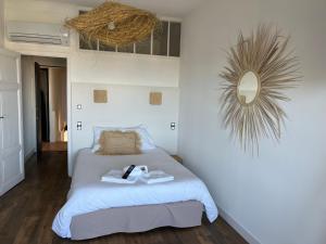 a bedroom with a bed and a mirror on the wall at Hôtel Paradis in Bormes-les-Mimosas