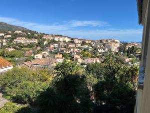 a view of a town with houses and trees at Hôtel Paradis in Bormes-les-Mimosas