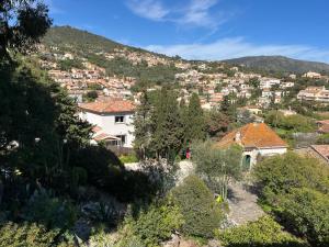 a view of a town with houses on a hill at Hôtel Paradis in Bormes-les-Mimosas