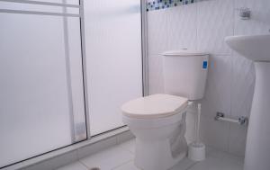 een witte badkamer met een toilet en een douche bij APARTAMENTO - AIRE ACONDICIONADO in Valledupar