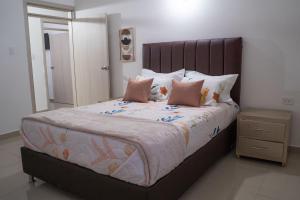 a bedroom with a large bed with pink pillows at APARTAMENTO - AIRE ACONDICIONADO in Valledupar
