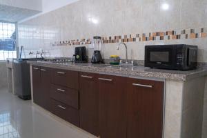 a kitchen with a counter top with a microwave at APARTAMENTO - AIRE ACONDICIONADO in Valledupar