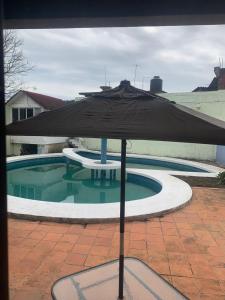 - un parasol noir à côté de la piscine dans l'établissement Casa Familiar, à Catemaco