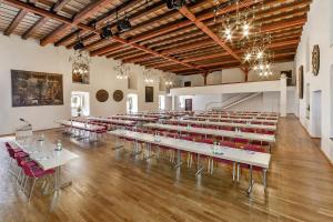 Habitación grande con mesas y sillas rojas. en Hotel Klösterle Nördlingen en Nördlingen