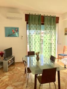 a living room with a table and chairs and a television at Le Case della Costa - Appartamento Capri in Maiori