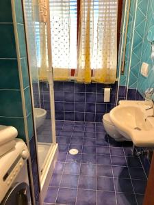 a blue tiled bathroom with a sink and a toilet at Le Case della Costa - Appartamento Capri in Maiori