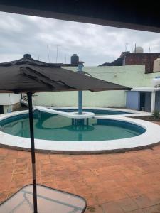 - un parasol à côté d'une petite piscine dans l'établissement Casa Familiar, à Catemaco