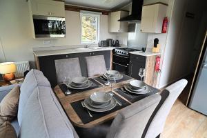 una cocina con una mesa con platos y vasos. en Hobbit - Holiday Lodge, en Longridge