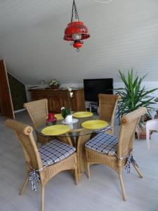 mesa de comedor con sillas, mesa y lámpara de araña en Schöne Ferienwohnung am Wald gelegen mit großem Sonnenbalkon, 