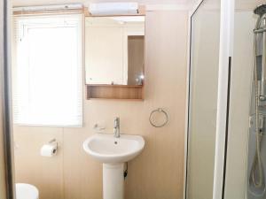 une salle de bain avec un lavabo et une douche dans l'établissement Dog Friendly 3 Bedroom Static Caravan In Fritton, à Belton 21 autres photos