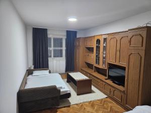 a bedroom with two beds and a large wooden cabinet at Apartman NINA in Kuršumlija