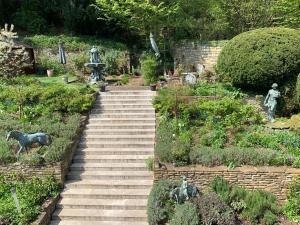 un escalier dans un jardin avec des statues dans l'établissement Remedium Appartements, à Vlotho