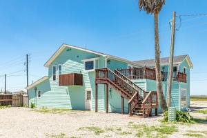 a house with a palm tree in front of it at Beach & Bay Views - Unit 2 - Bluewater Beach House in Surfside Beach